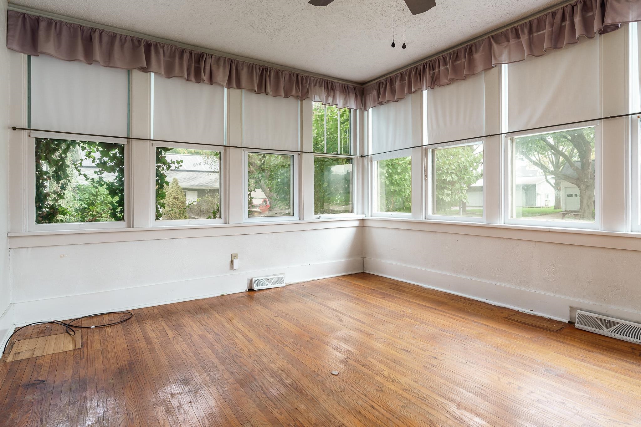 305 West 3rd Street Byron, IL 61010 - Photo 16 of 37 a view of an empty room with wooden floor and a window