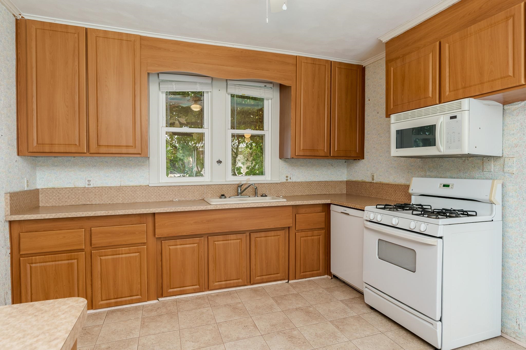 305 West 3rd Street Byron, IL 61010 - Photo 21 of 37 a kitchen with cabinets appliances and a window