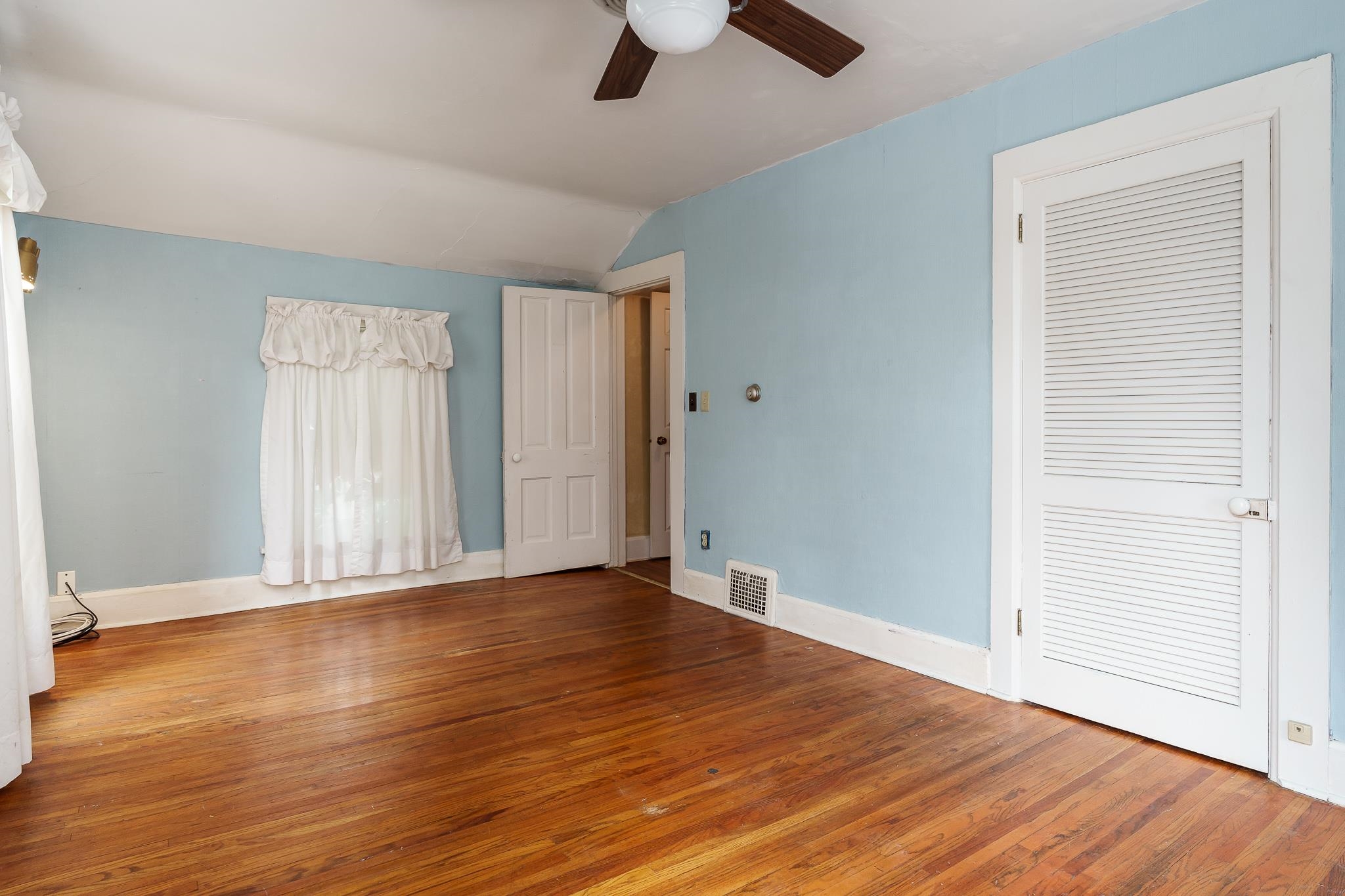 305 West 3rd Street Byron, IL 61010 - Photo 26 of 37 an empty room with wooden floor chandelier fan and windows