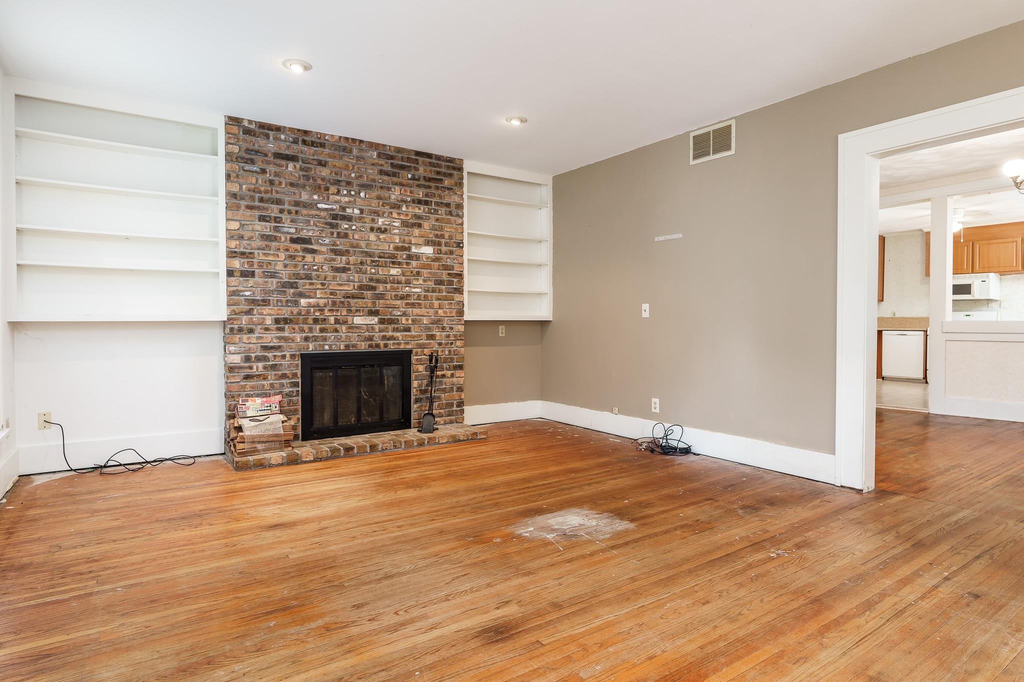 305 West 3rd Street Byron, IL 61010 - Photo 7 of 37 a view of empty room with wooden floor and fireplace