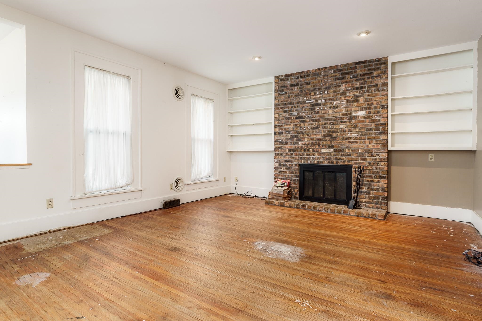 305 West 3rd Street Byron, IL 61010 - Photo 8 of 37 a view of an empty room with a fireplace and a window
