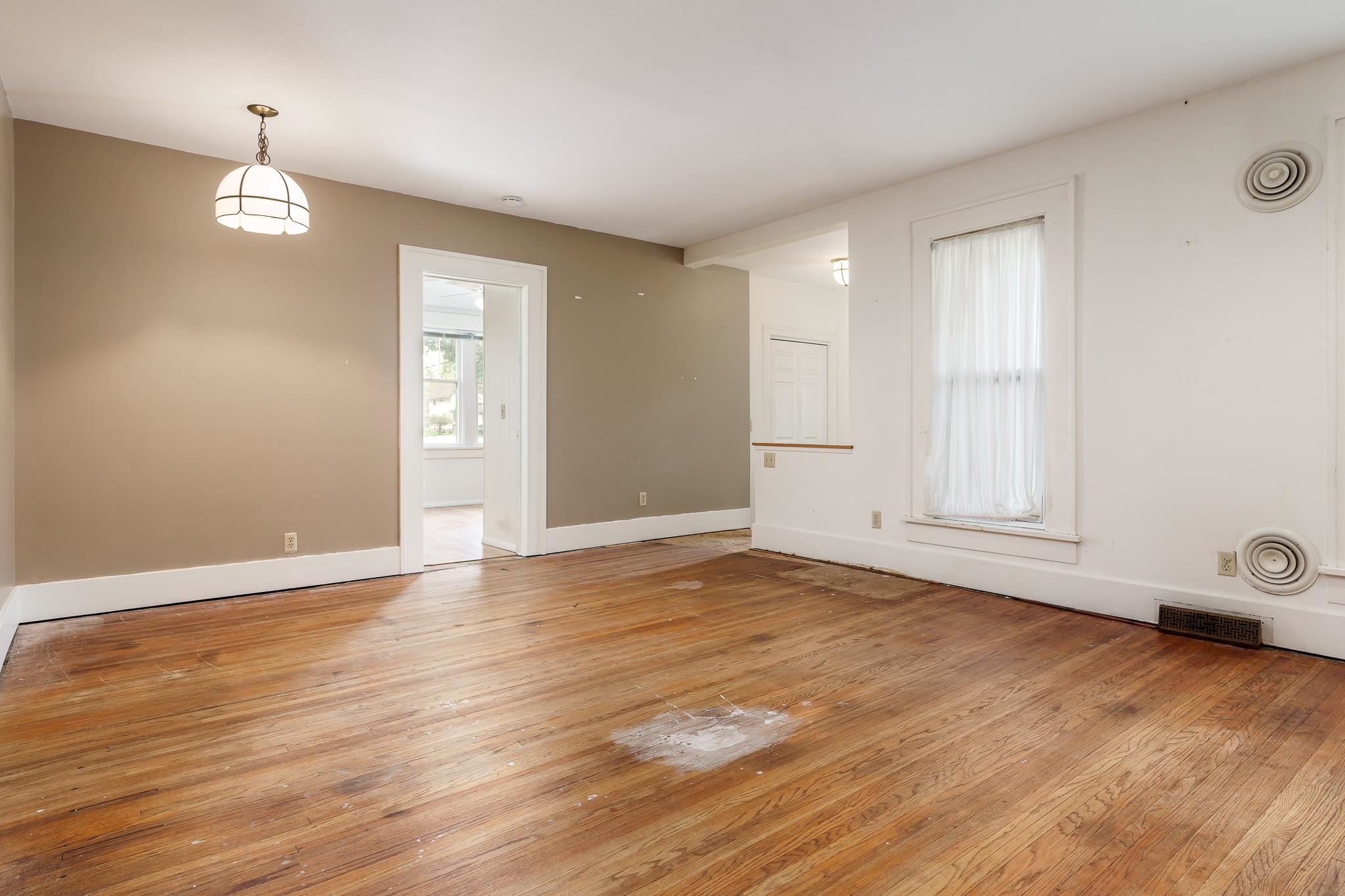 305 West 3rd Street Byron, IL 61010 - Photo 10 of 37 an empty room with wooden floor and window