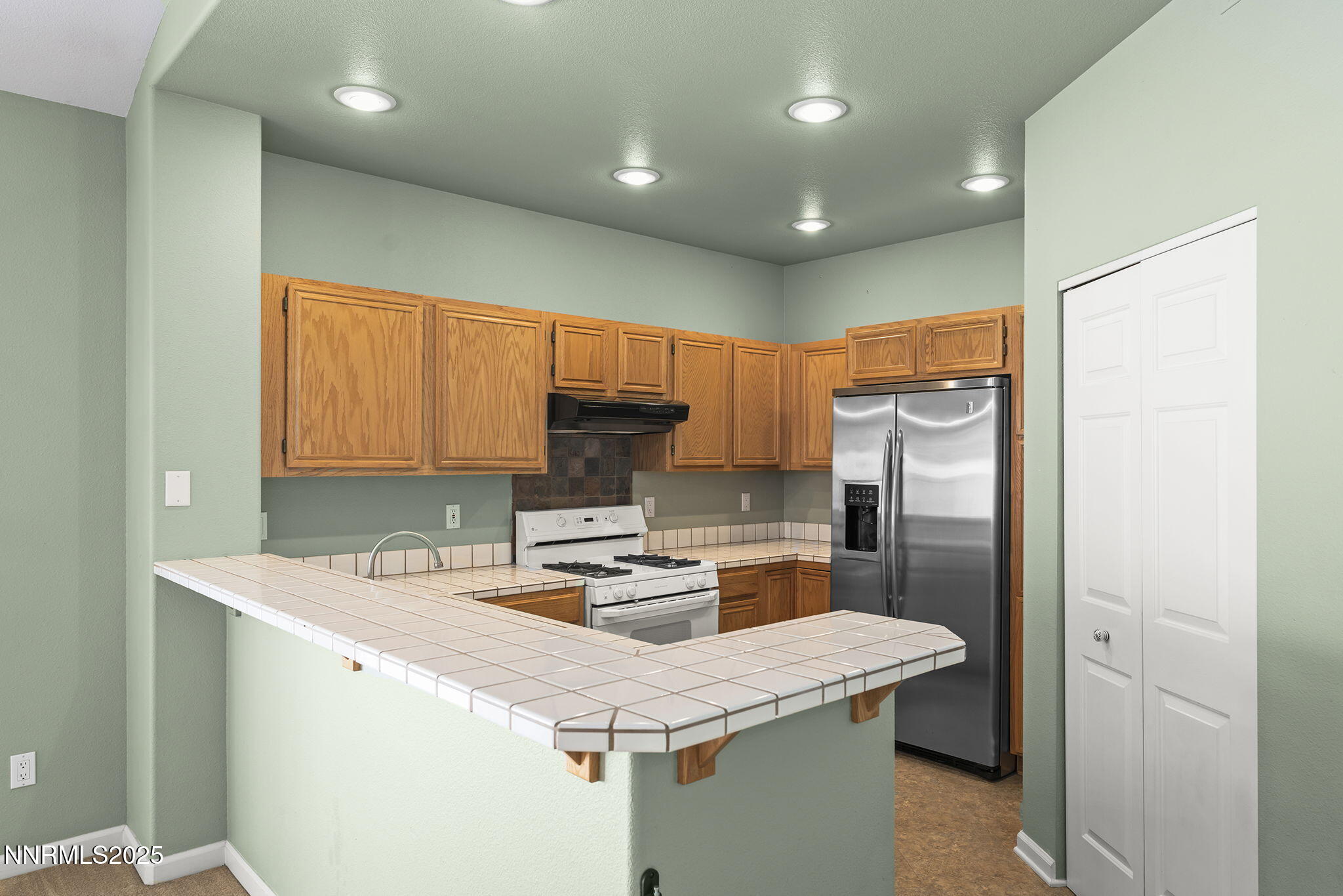 825 Caughlin Crossing, Unit CAUGHLIN RANCH PKWY Reno, NV 89519 - Photo 11 of 35 a kitchen with stainless steel appliances granite countertop a sink a refrigerator and a stove