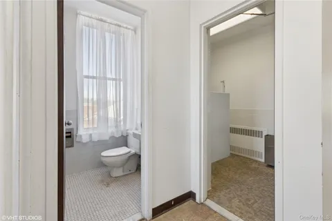 a view of hallway with a glass door shower door and a white door