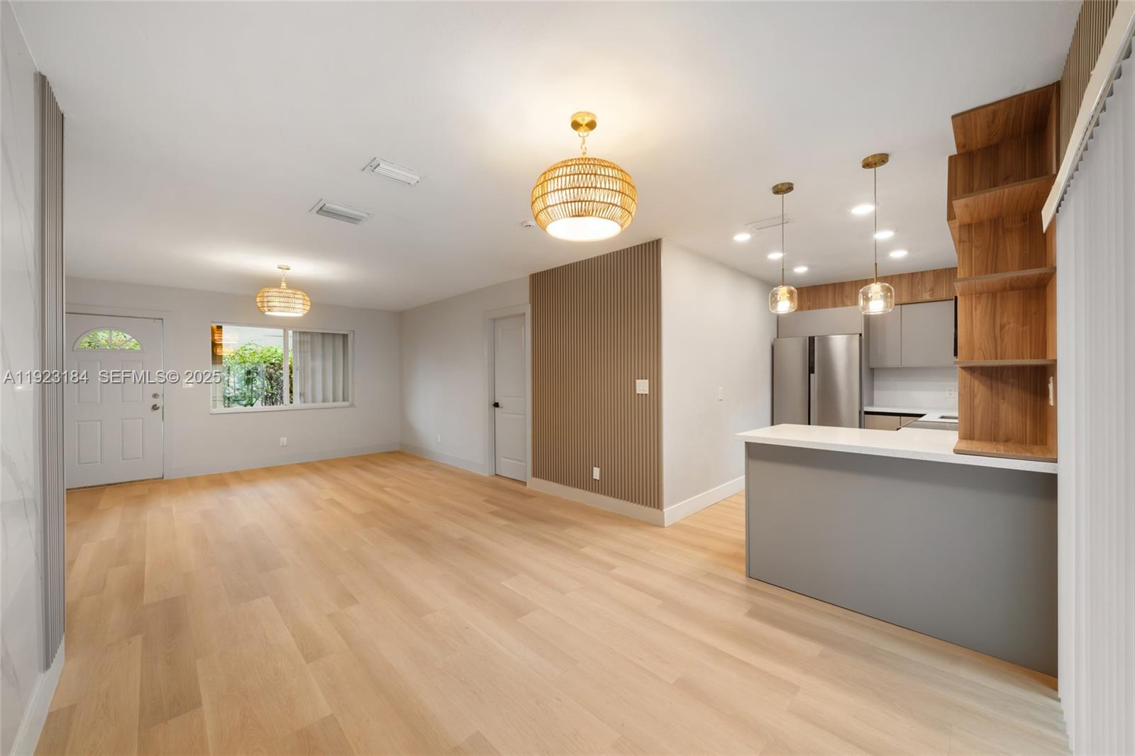 2350 Northwest 56th Street Miami, FL 33142 - Photo 1 of 22 a view of an empty room and kitchen with wooden floor