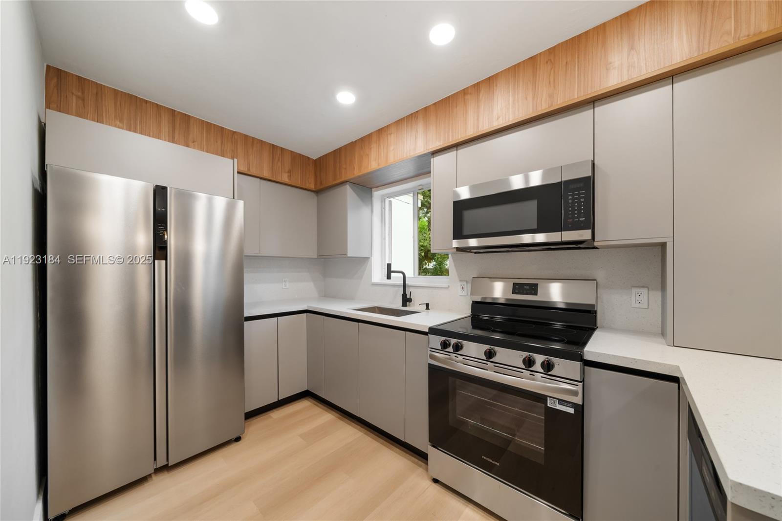 2350 Northwest 56th Street Miami, FL 33142 - Photo 4 of 22 a kitchen with stainless steel appliances a refrigerator stove and microwave