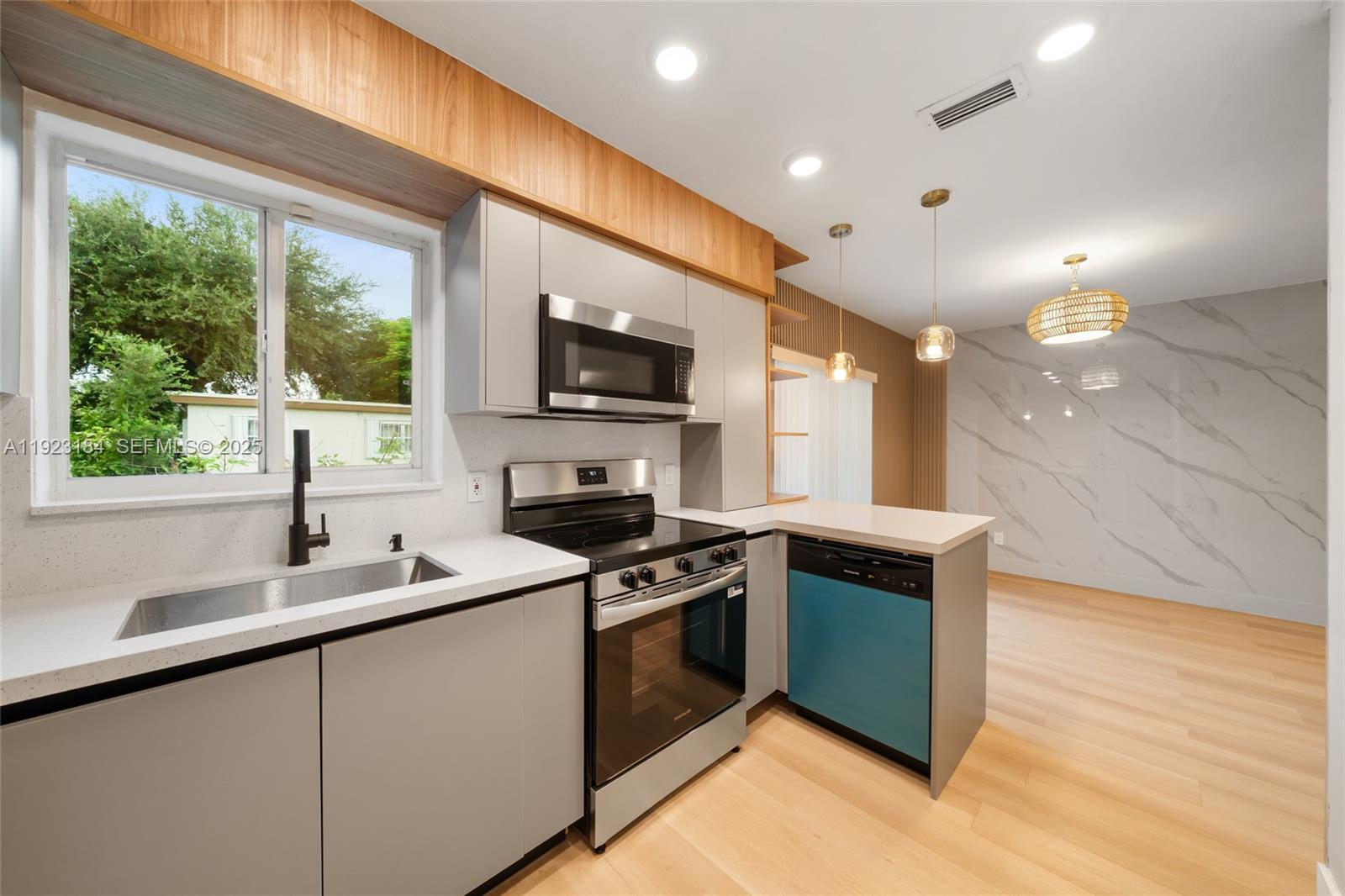 2350 Northwest 56th Street Miami, FL 33142 - Photo 5 of 22 a kitchen with kitchen island granite countertop a stove top oven a sink a counter space and cabinets