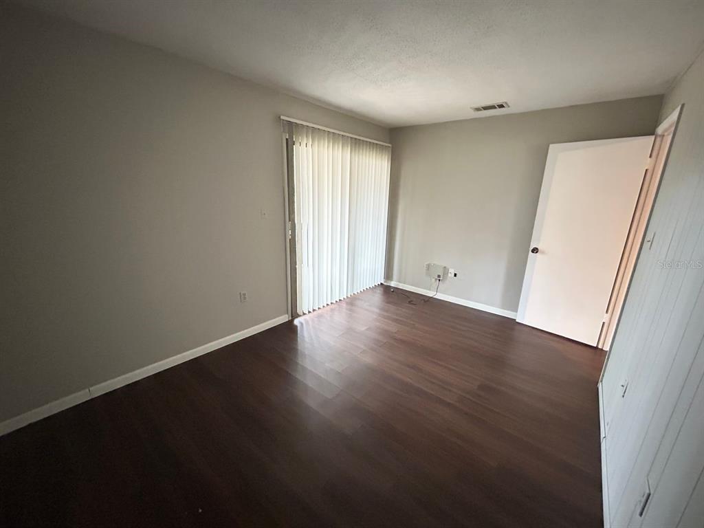 2811 Southwest Archer Road, Unit C18 Gainesville, FL 32608 - Photo 15 of 15 an empty room with wooden floor and window