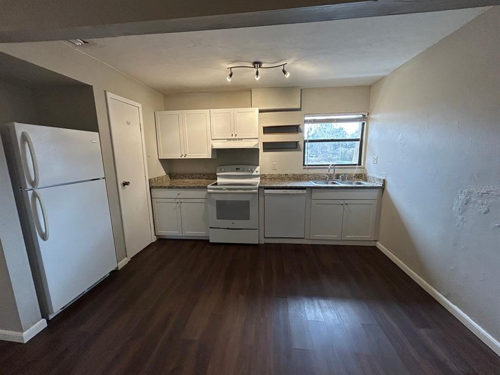 2811 Southwest Archer Road, Unit C18 Gainesville, FL 32608 - Photo 7 of 15 a kitchen with stainless steel appliances a sink cabinets and wooden floor