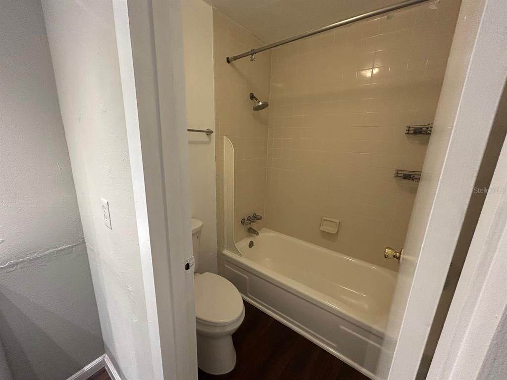 2811 Southwest Archer Road, Unit C18 Gainesville, FL 32608 - Photo 10 of 15 a bathroom with a granite countertop bathtub shower sink vanity and a toilet