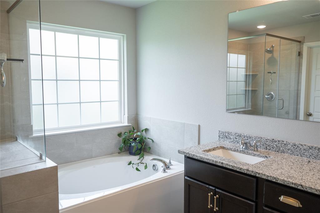7909 Townsend Drive Waco, TX 76708 - Photo 13 of 22 Soaking tub with a large privacy-frosted window and tile surround