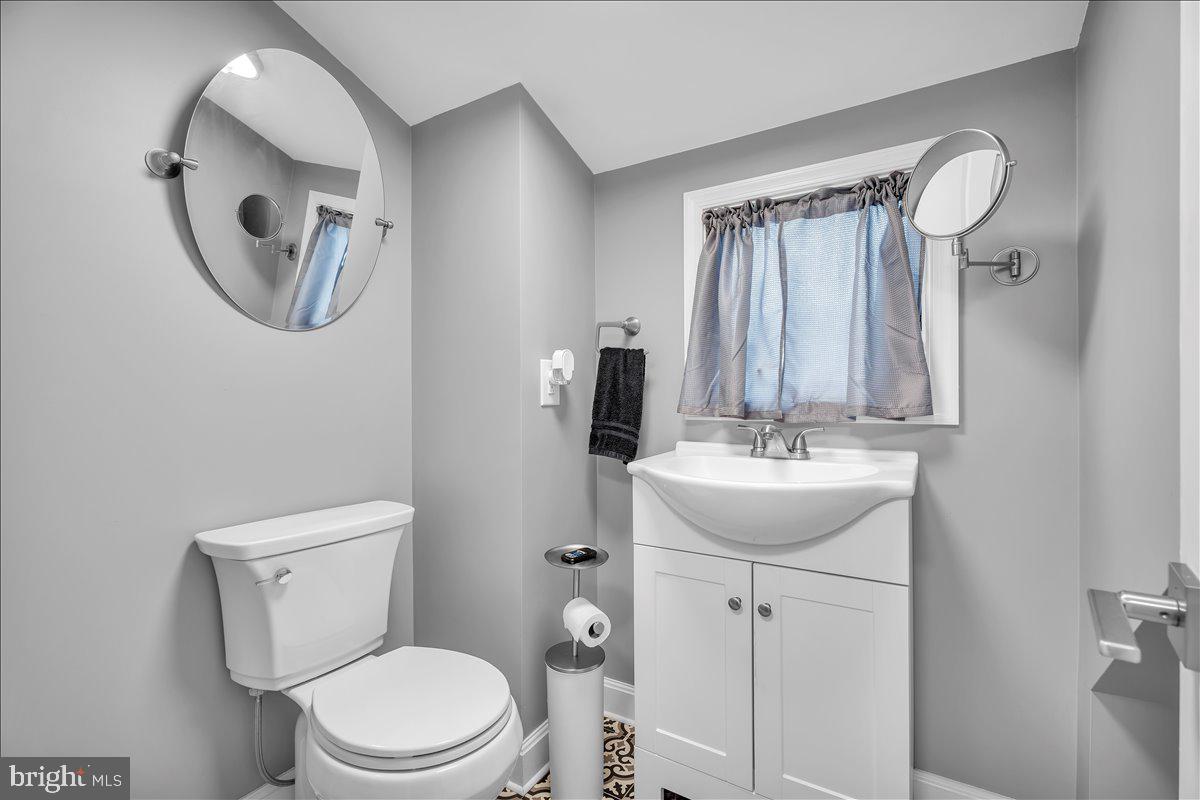 20 West Laurel Road Stratford, NJ 08084 - Photo 20 of 24 a bathroom with a toilet a sink and mirror