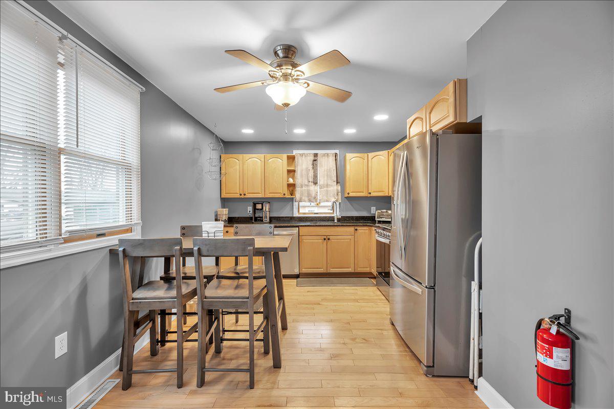 20 West Laurel Road Stratford, NJ 08084 - Photo 8 of 24 a kitchen with kitchen island granite countertop wooden floors and refrigerator