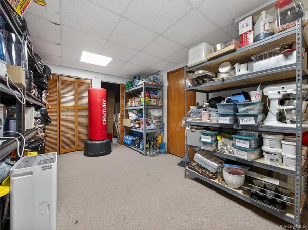 a room with lots of books and a refrigerator