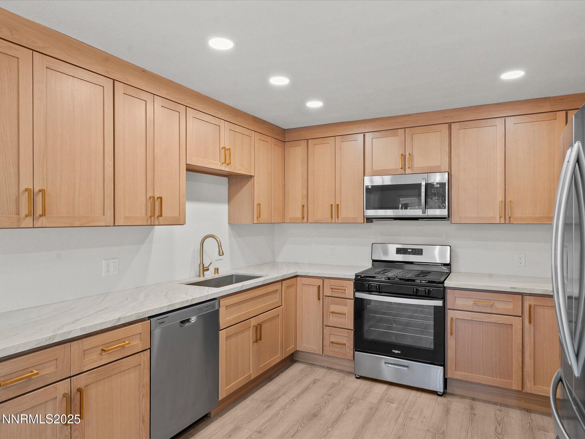 2940 Lukens Lane Carson City, NV 89706 - Photo 17 of 46 a kitchen with stainless steel appliances granite countertop white cabinets a sink a stove a refrigerator and microwave with wooden floor