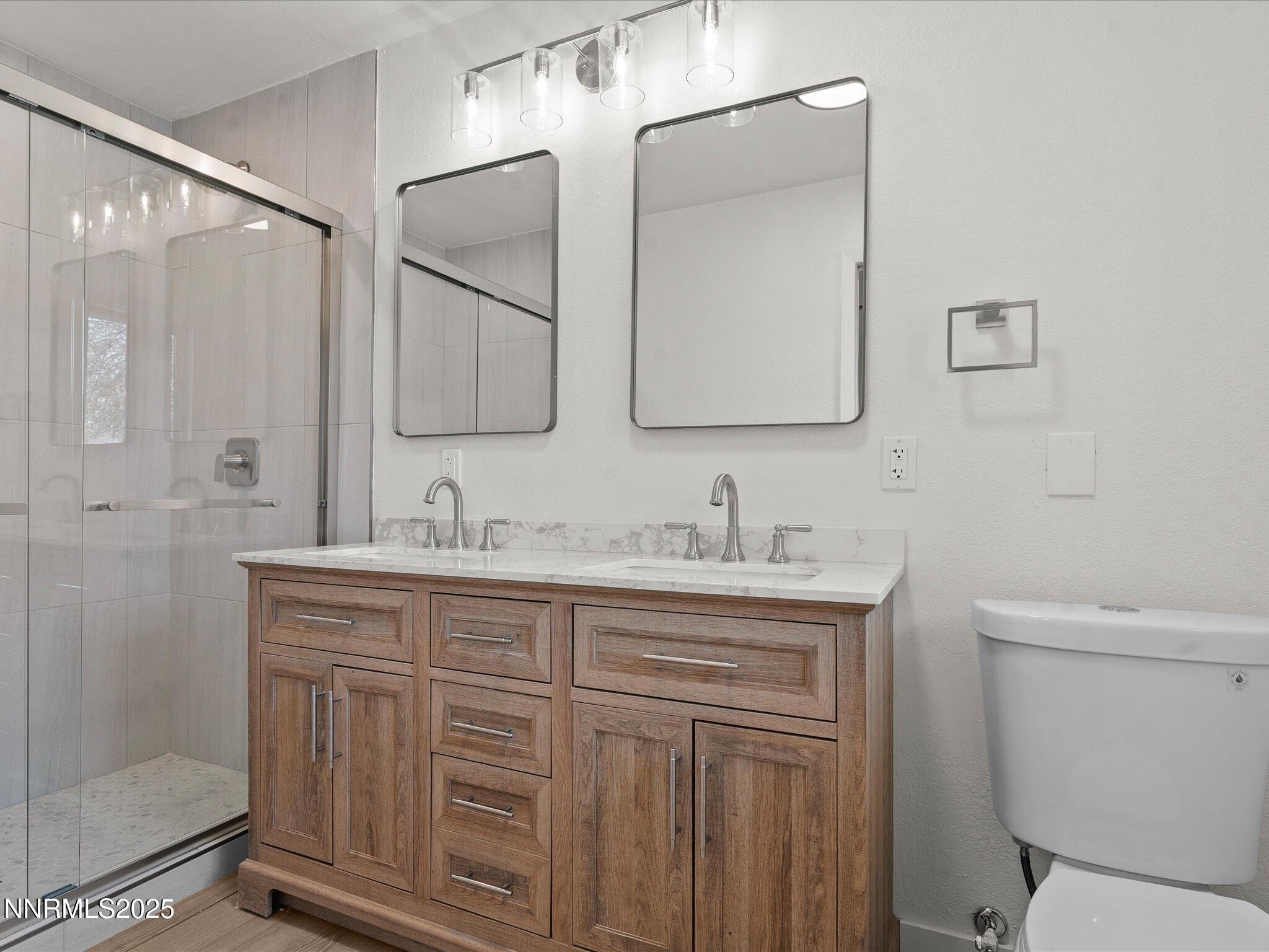 2940 Lukens Lane Carson City, NV 89706 - Photo 26 of 46 a bathroom with a granite countertop sink a toilet and a mirror