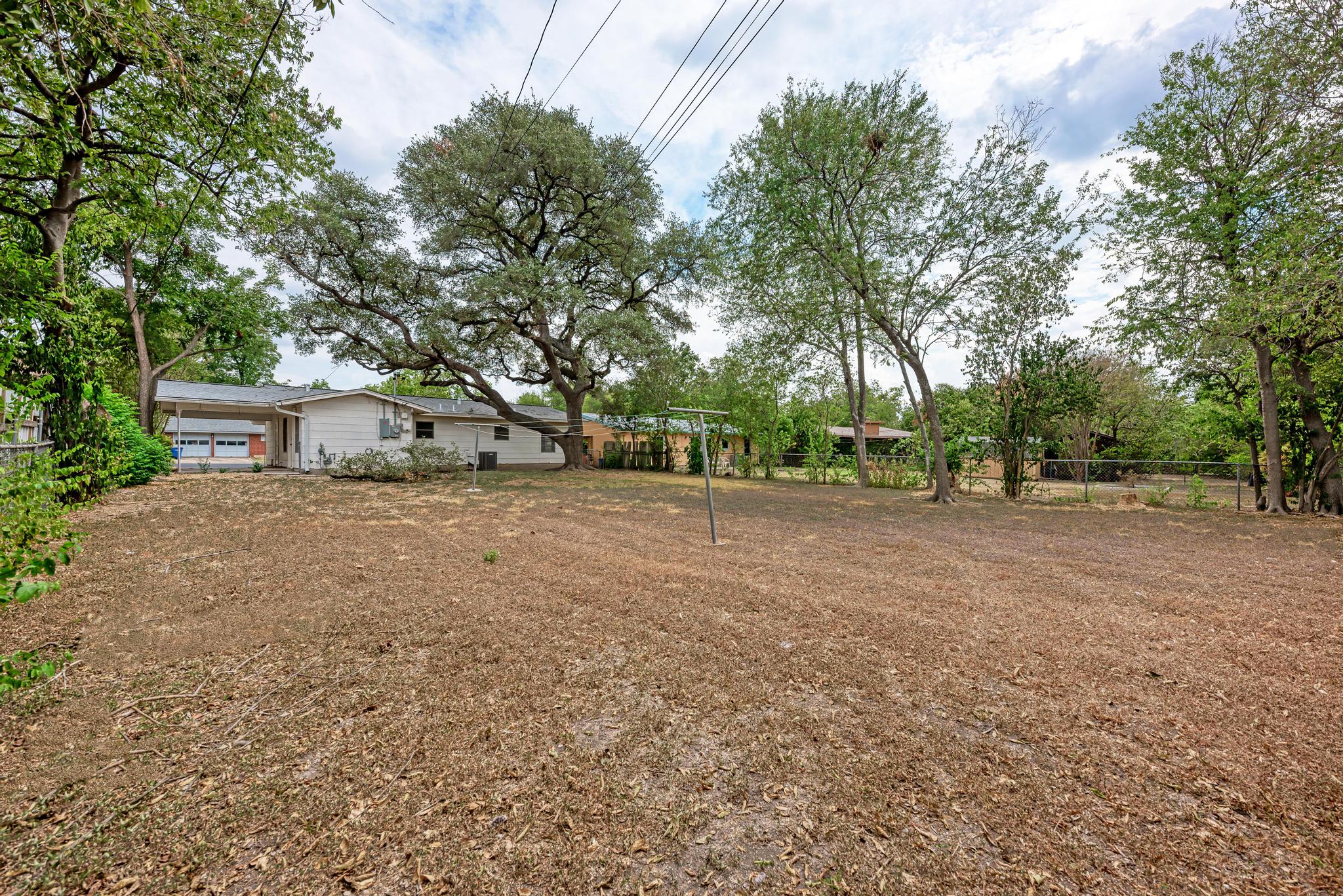 7804 Rutgers Avenue Austin, TX 78757 - Photo 22 of 32 Mature trees shade a massive backyard offering unlimited potential for outdoor recreation and expansion.