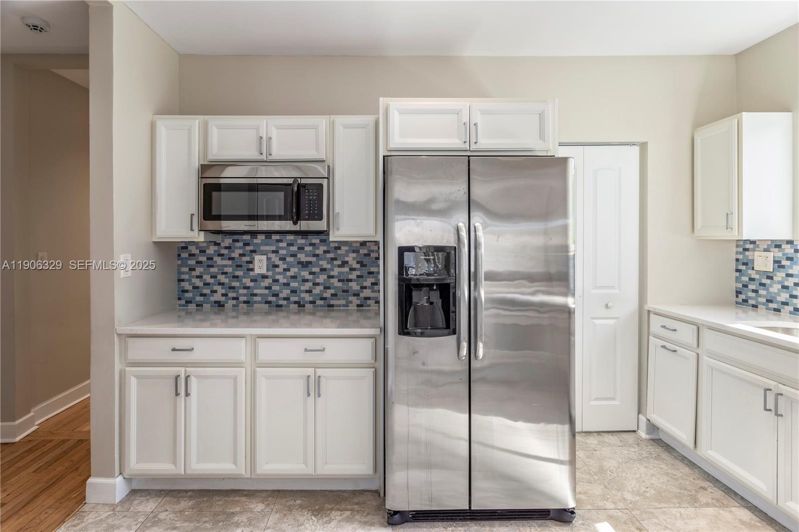 1776 Southwest 11th Terrace Miami, FL 33135 - Photo 9 of 25 a kitchen with white cabinets and stainless steel appliances