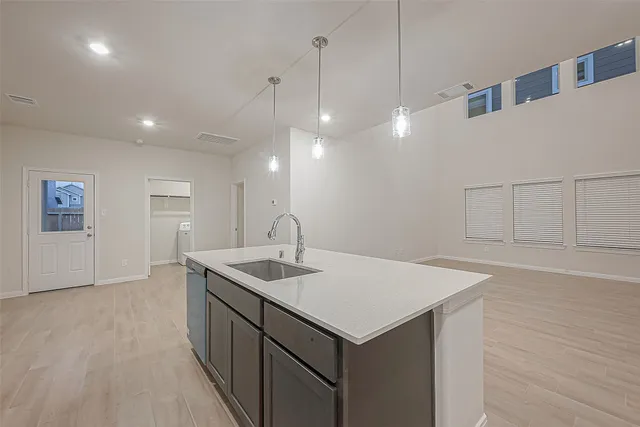 a kitchen with a sink a counter space and a refrigerator