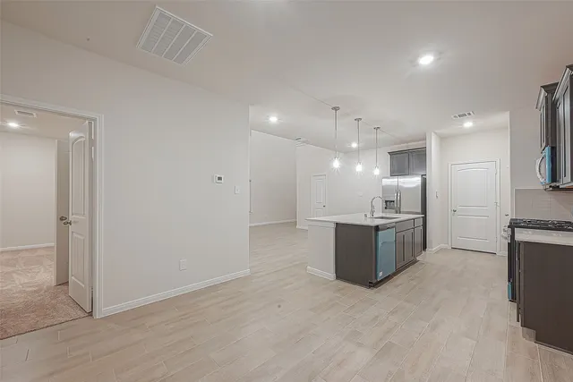 a large kitchen with a refrigerator and a stove top oven