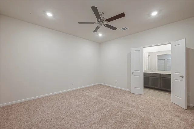an empty room with closet and windows