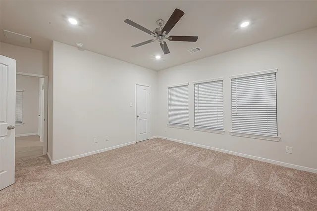 an empty room with closet and windows