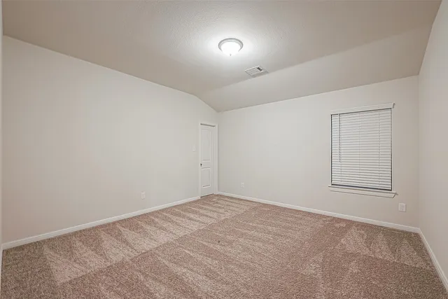 an empty room with a fan and windows