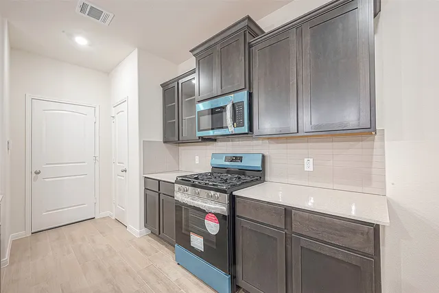 a kitchen with stainless steel appliances granite countertop a stove and a microwave