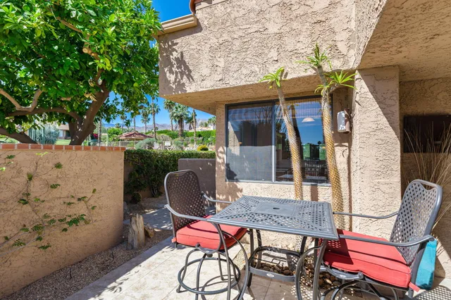 a view of a dining room with furniture a chandelier and large windows