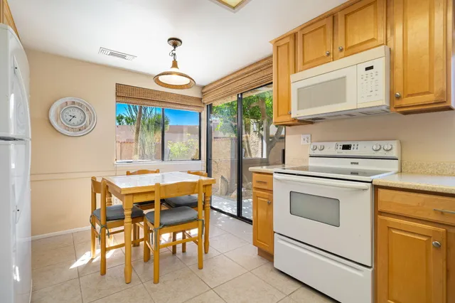 a kitchen with white cabinets and refrigerator