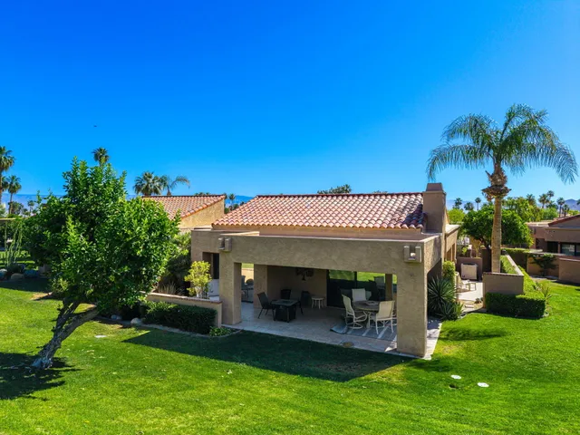 a view of a swimming pool and lounge chairs in patio