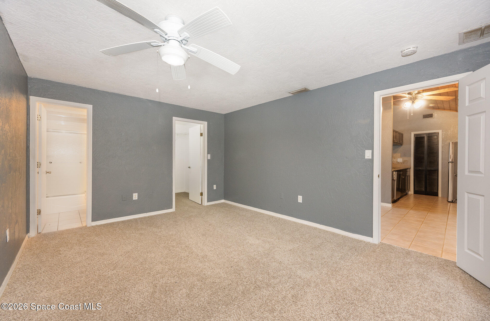 696 Las Palmas Way Melbourne, FL 32940 - Photo 12 of 21 an empty room with fan and hallway