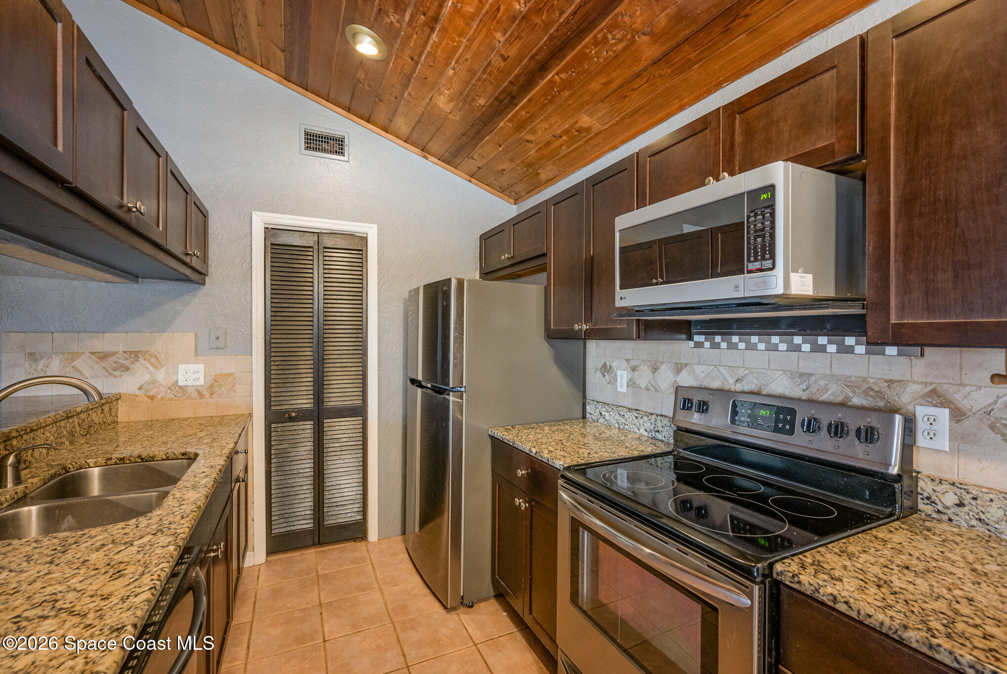 696 Las Palmas Way Melbourne, FL 32940 - Photo 9 of 21 a kitchen with stainless steel appliances granite countertop a stove and a microwave