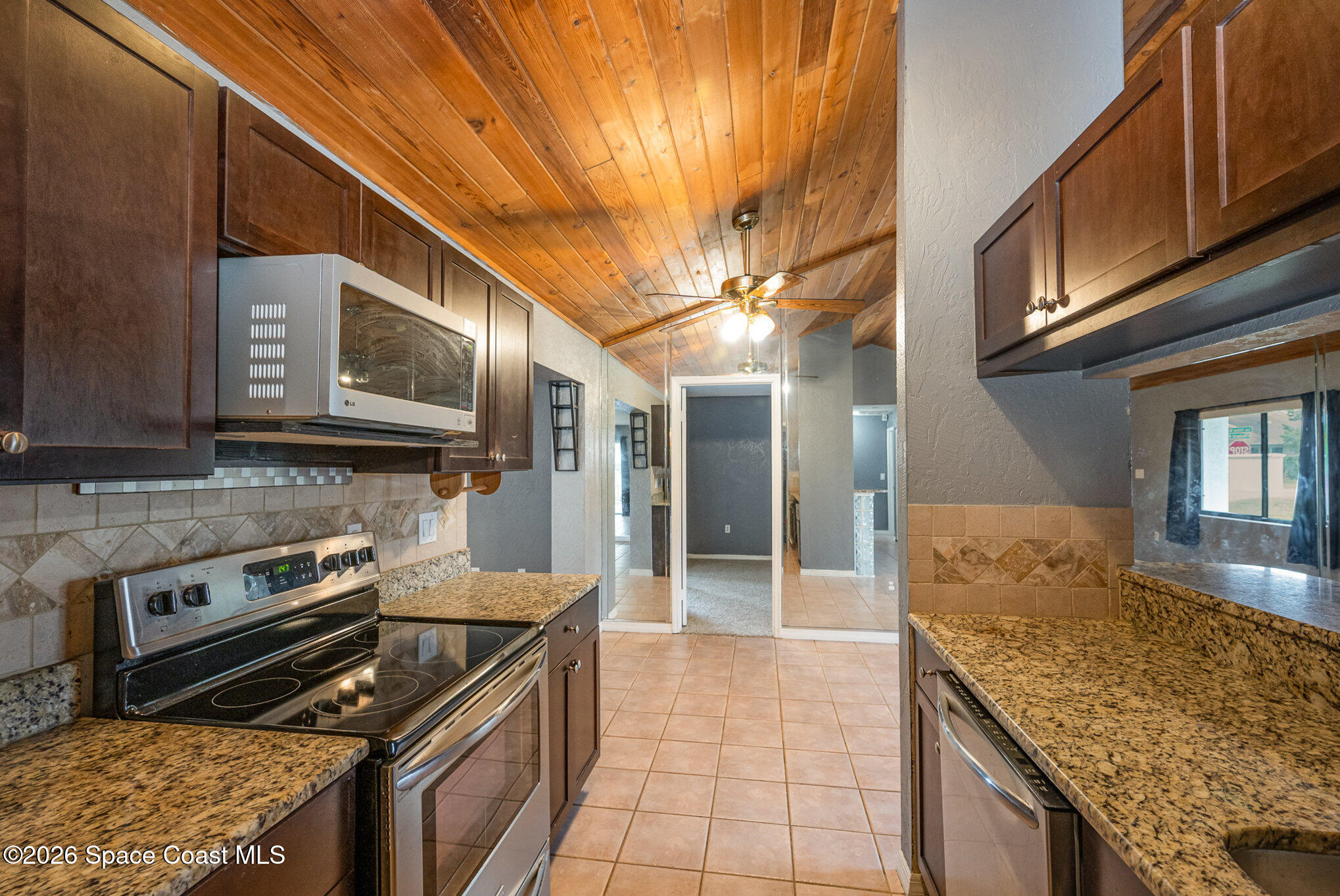 696 Las Palmas Way Melbourne, FL 32940 - Photo 10 of 21 a kitchen with stainless steel appliances granite countertop a stove a sink and a microwave