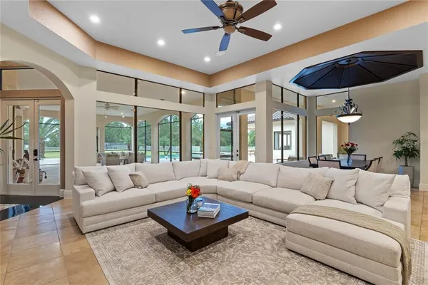 a living room with furniture and floor to ceiling windows