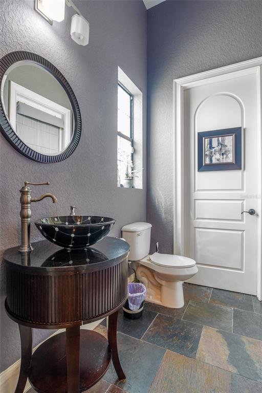 5251 Carson Street St. Cloud, FL 34771 - Photo 26 of 60 a bathroom with a toilet a sink and a mirror