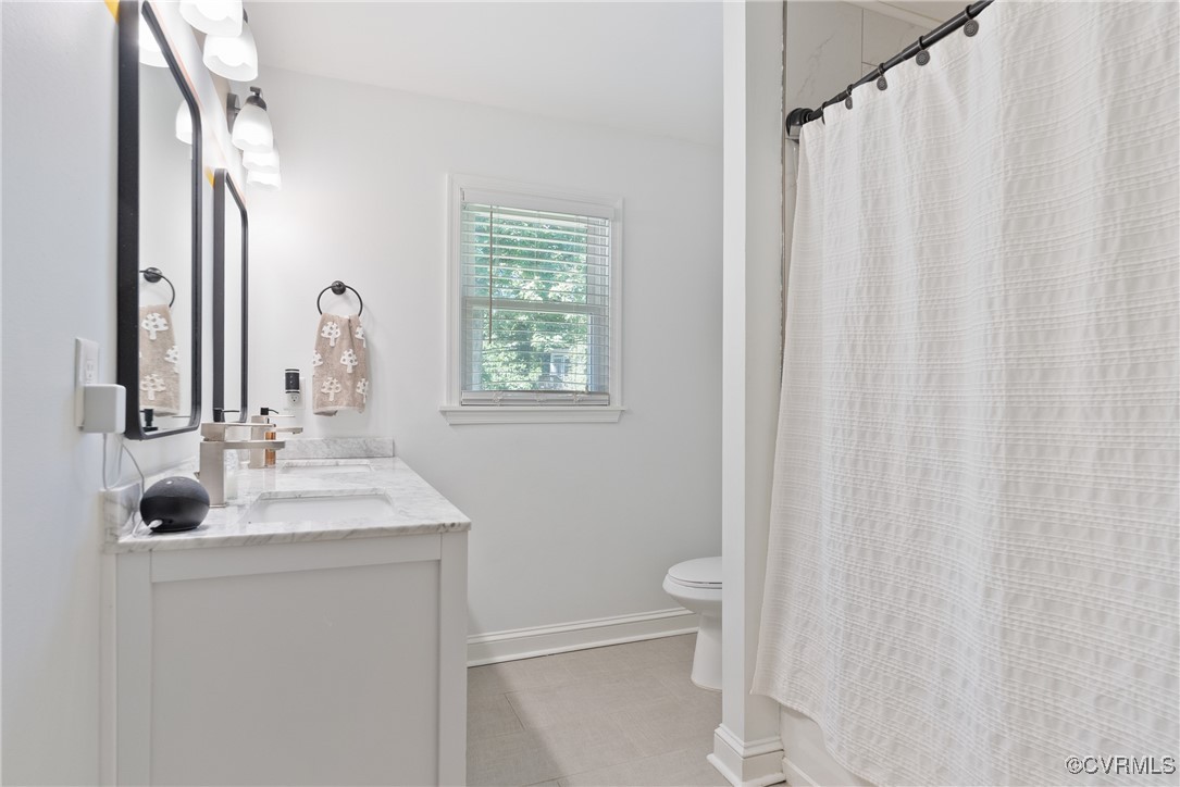 5018 Grassmere Road Richmond, VA 23234 - Photo 13 of 34 Bathroom with toilet, vanity, baseboards, and a sh
