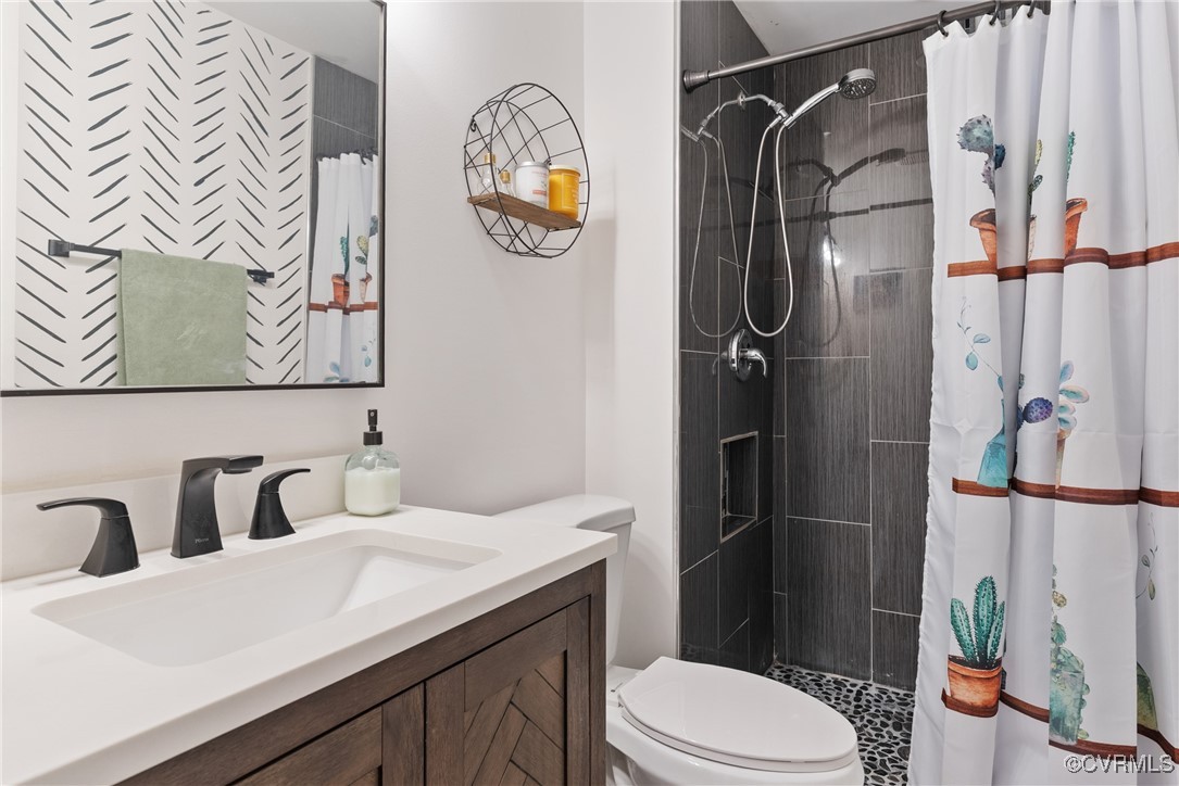 5018 Grassmere Road Richmond, VA 23234 - Photo 22 of 34 Full bathroom featuring a tile shower, toilet, and