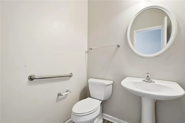 a bathroom with a sink a toilet and a mirror
