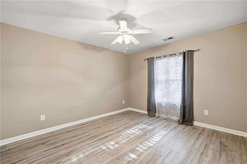 331 Oakview Way Canton, GA 30114 - Photo 22 of 42 an empty room with wooden floor fan and windows