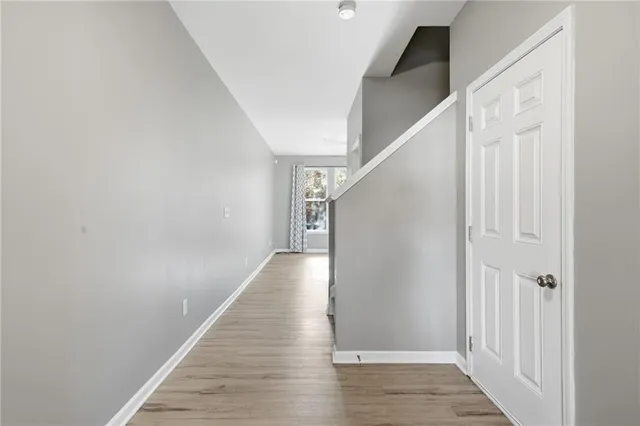 a view of a hallway with wooden floor and staircase