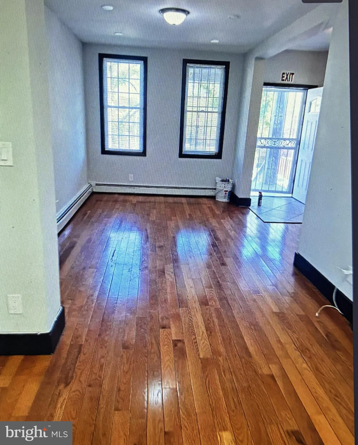 4754 Alhambra Avenue Baltimore, MD 21212 - Photo 2 of 10 an empty room with wooden floor and windows