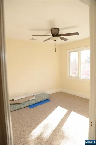 a view of a room with an empty space and a ceiling fan