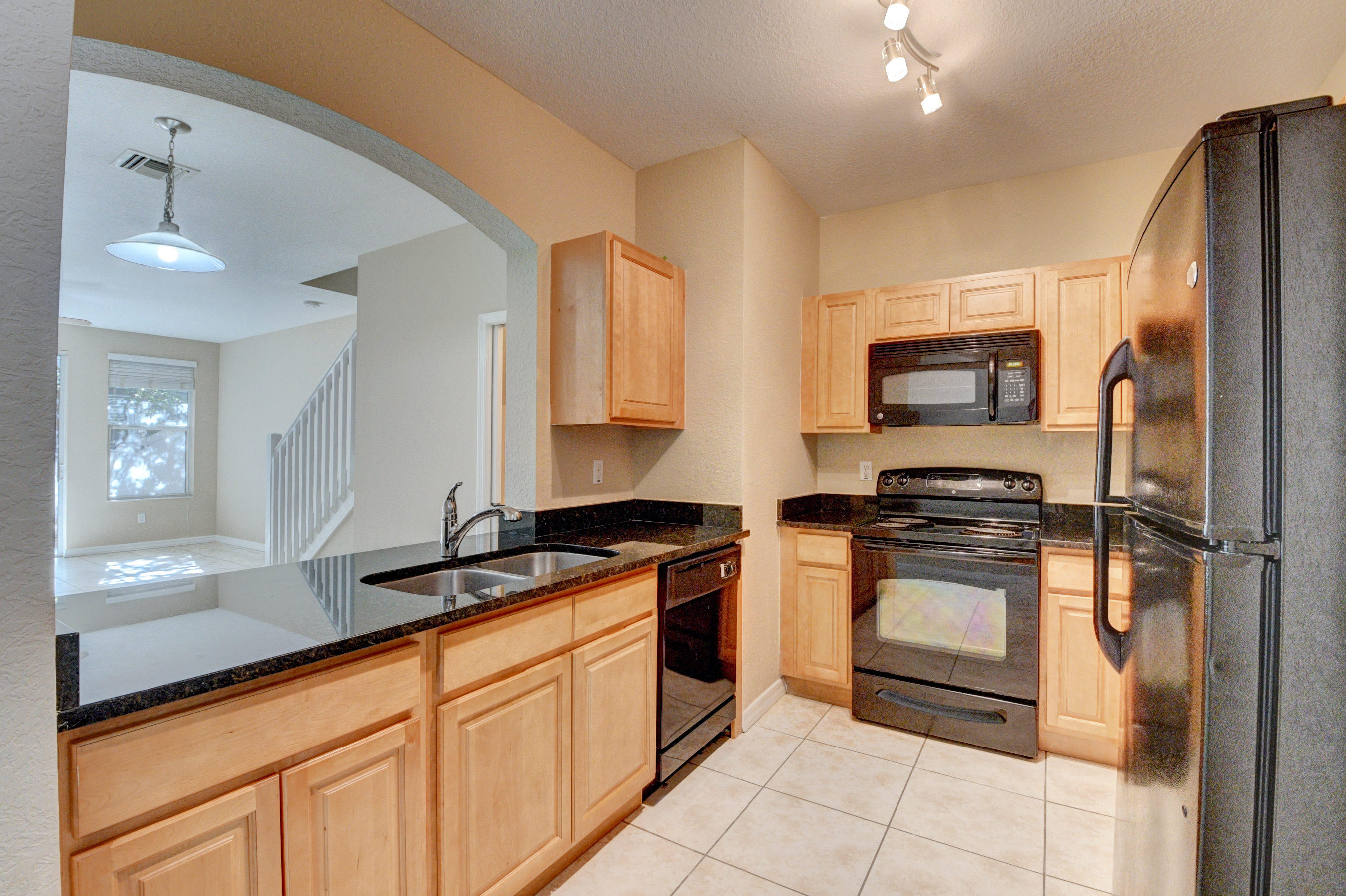 116 Williams Court Palm Springs, FL 33461 - Photo 4 of 17 a kitchen with stainless steel appliances granite countertop a stove a sink and a refrigerator