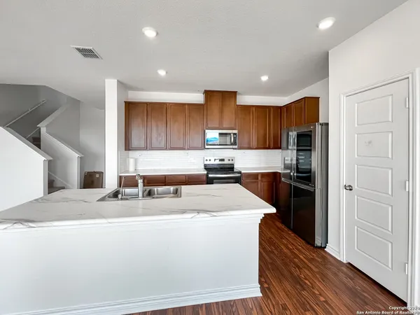 a kitchen with stainless steel appliances granite countertop a refrigerator sink and cabinets