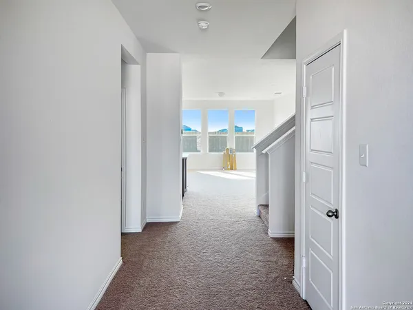 a view of a room with an empty space and a hallway