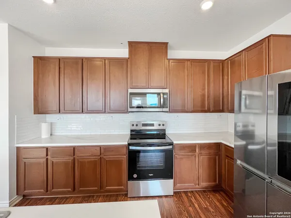 a kitchen with granite countertop wooden cabinets and stainless steel appliances