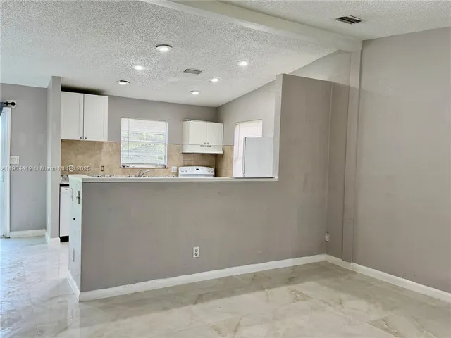a view of kitchen with kitchen island and stainless steel appliances
