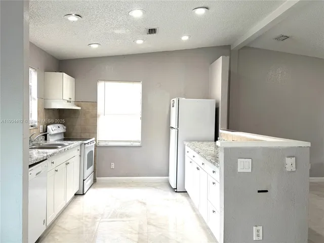 a view of a kitchen cabinets and empty room