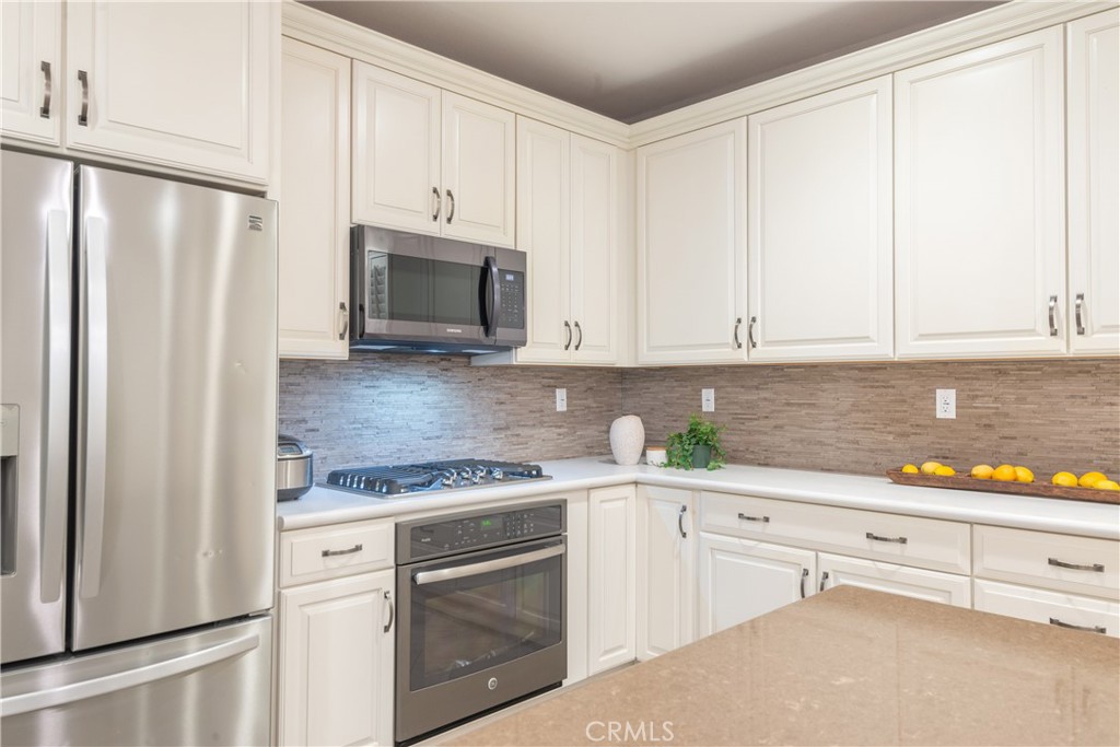 120 Mongoose Irvine, CA 92618 - Photo 18 of 42 a kitchen with white cabinets and white appliances